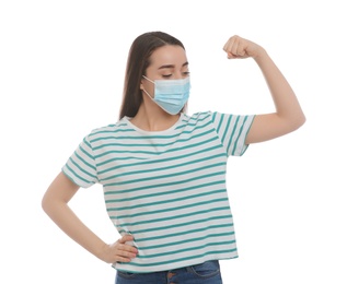 Woman with protective mask showing muscles on white background. Strong immunity concept