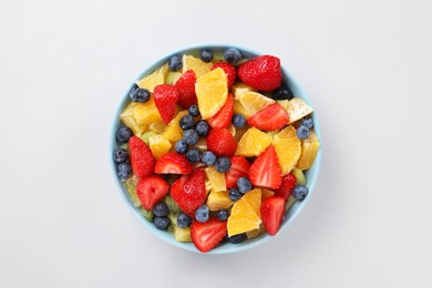 Yummy fruit salad in bowl on light grey background, top view