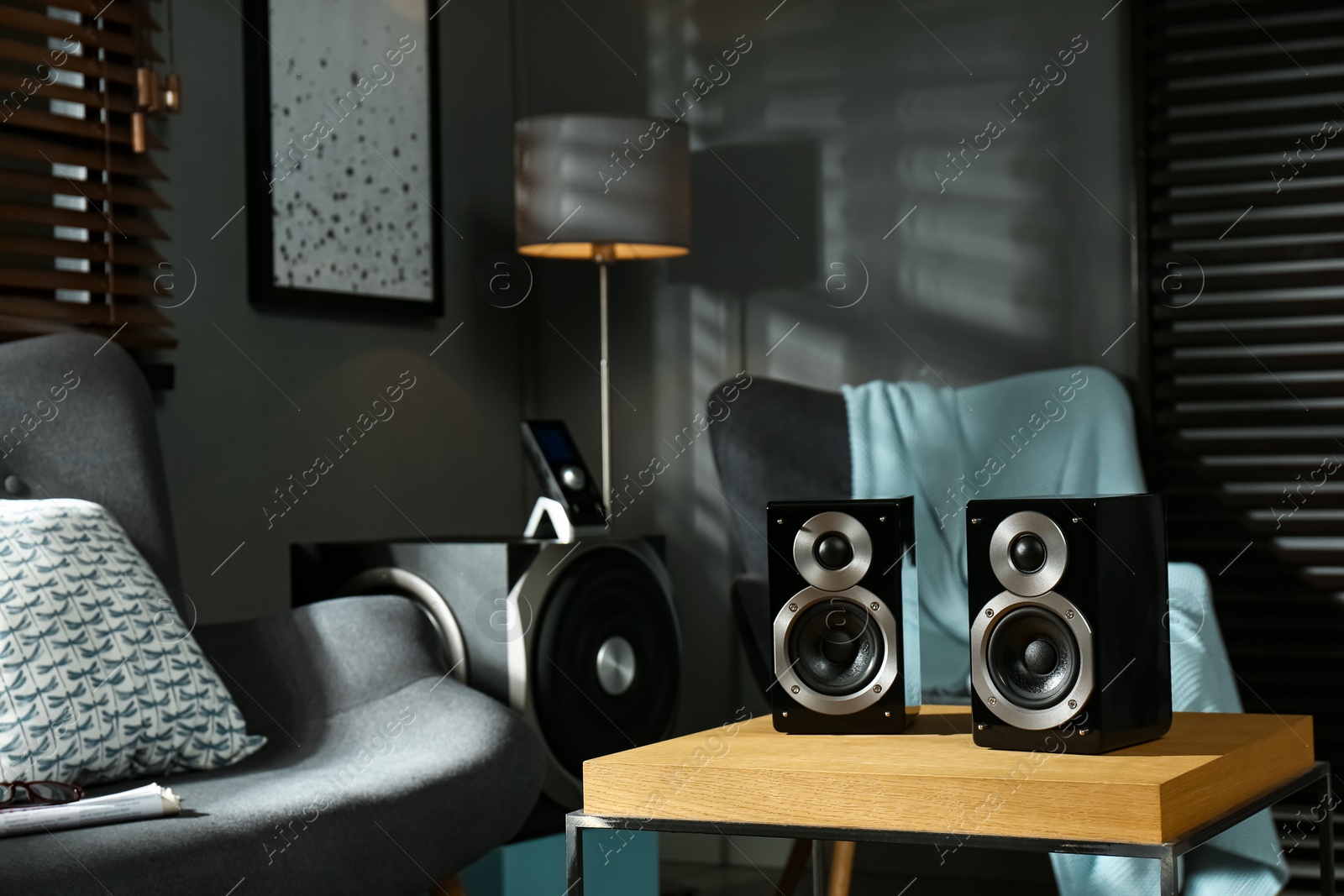 Photo of Modern audio speaker system on wooden table in living room