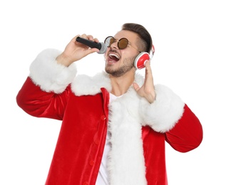 Young man in Santa costume singing into microphone on white background. Christmas music