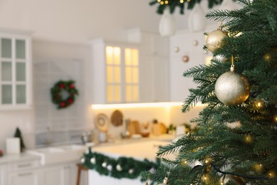 Closeup view of beautiful decorated Christmas tree in kitchen. Space for text