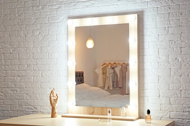 Photo of Makeup mirror on table near white wall in dressing room