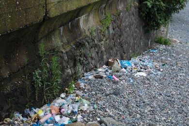 Garbage scattered on pebbles outdoors. Recycling problem