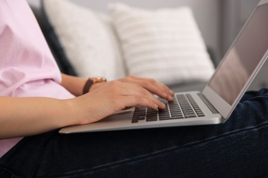 Photo of Woman with laptop on sofa at home, closeup