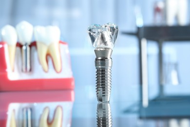 Educational model of dental implant on blurred background