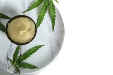 Photo of Plate with bowl of hemp lotion and leaves on light background, top view