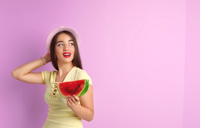 Beautiful young woman posing with watermelon on color background