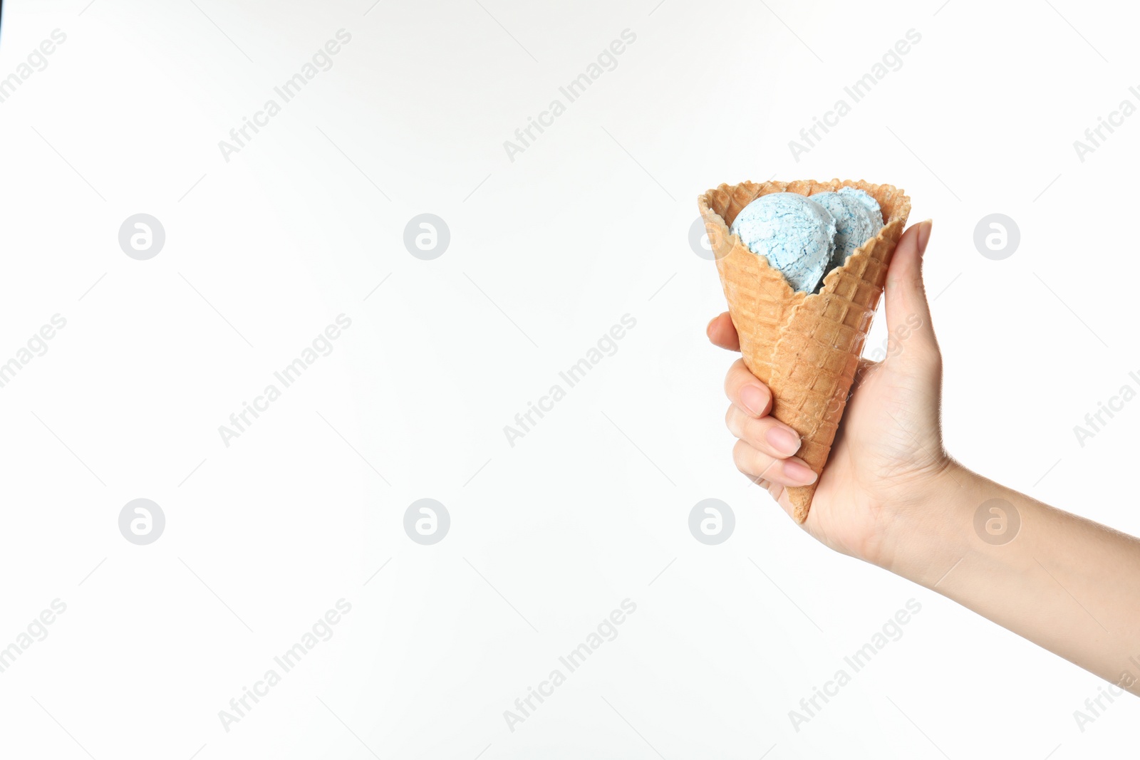 Photo of Woman holding delicious ice cream in waffle cone on white background, closeup