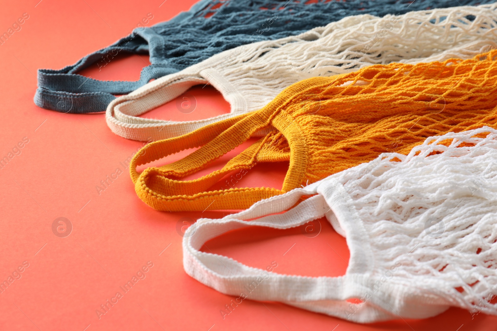 Photo of Different string bags on red background, closeup