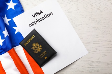 Flat lay composition with flag of USA, passport and visa application on wooden background