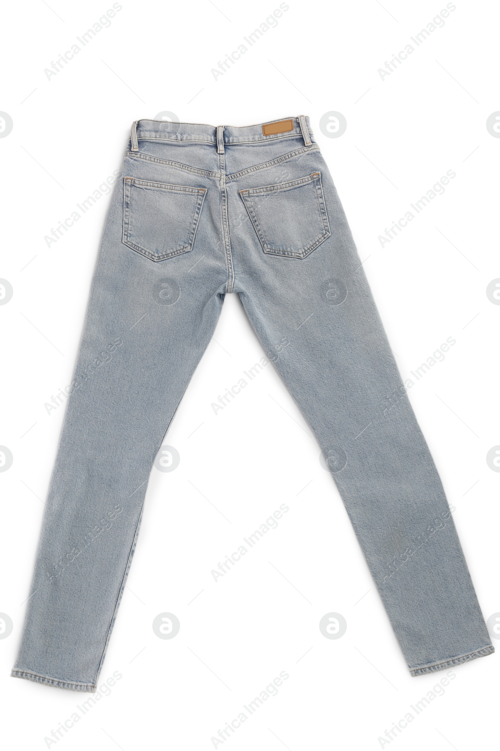 Photo of Light blue jeans isolated on white, top view. Stylish clothes