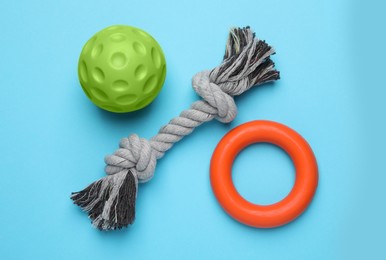 Photo of Different pet toys on light blue background, flat lay