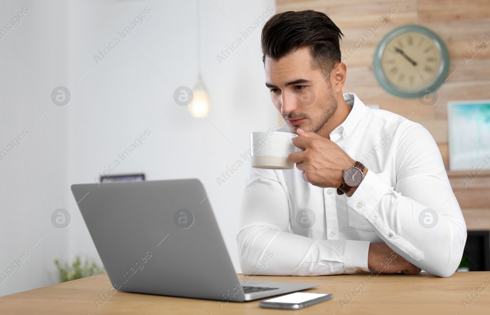 Photo of Portrait of handsome young man with laptop in office
