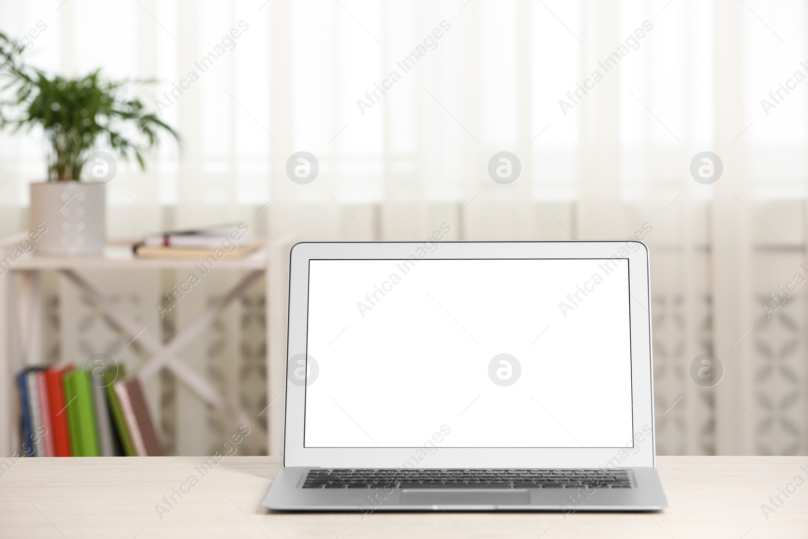 Photo of Modern laptop with blank screen on table at home