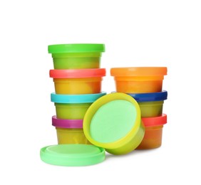 Plastic containers with colorful play dough on white background