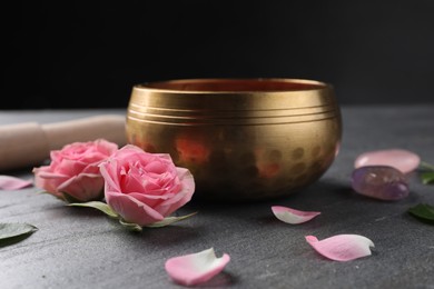 Tibetan singing bowl and beautiful rose flowers on gray table