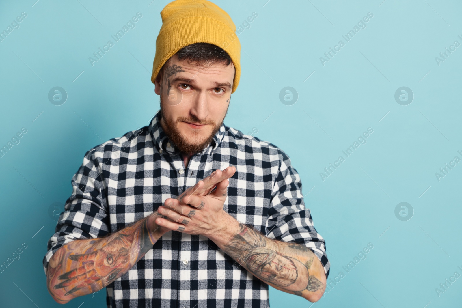 Photo of Portrait of handsome hipster man on light blue background. Space for text