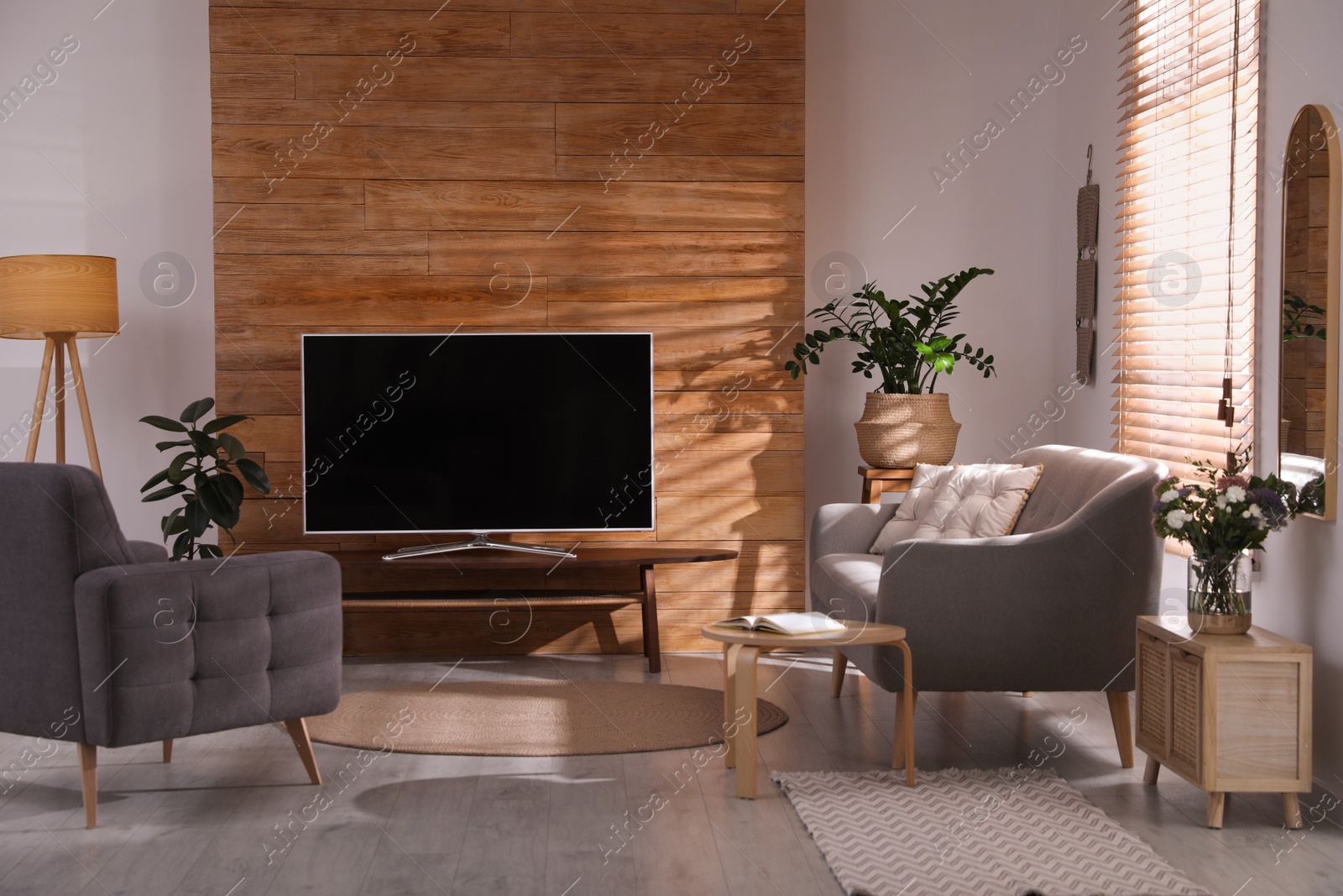 Photo of Stylish living room interior with TV on table and houseplants 