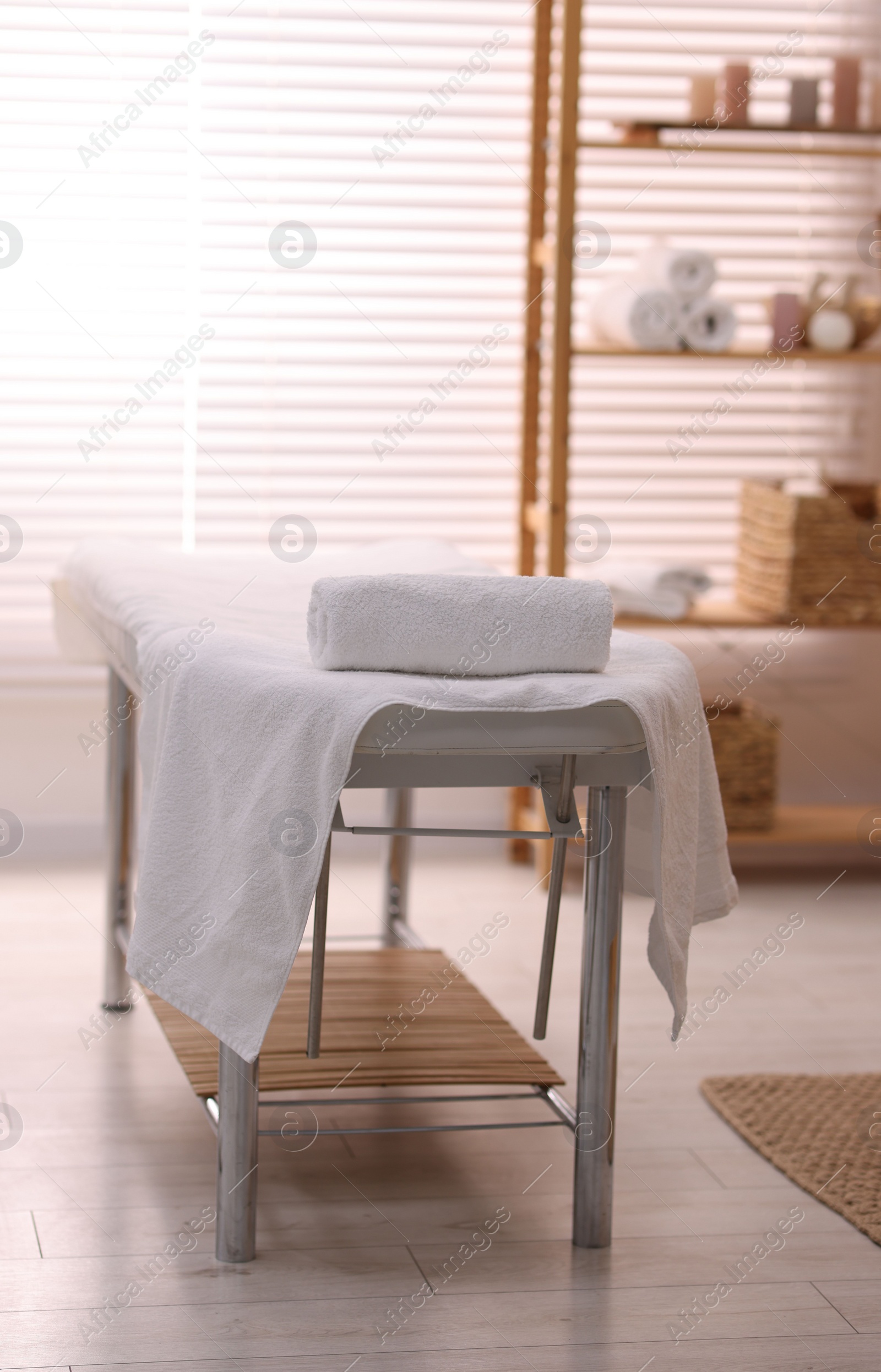 Photo of Comfortable massage table with clean towels in spa center