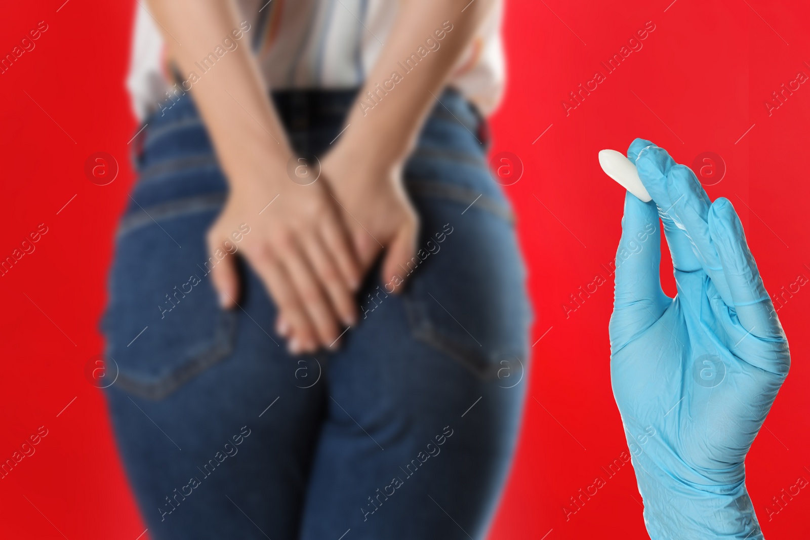 Image of Doctor holding suppository for hemorrhoid treatment and woman suffering from pain on red background, closeup