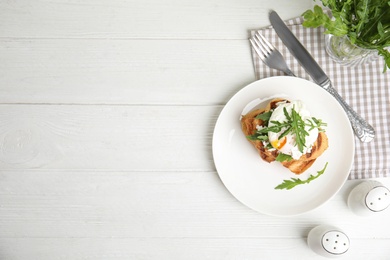 Delicious sandwich with arugula and egg on white wooden table, flat lay. Space for text