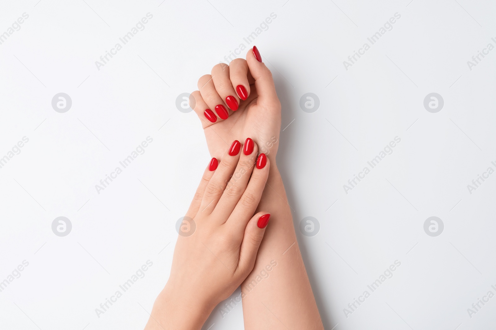 Photo of Woman with red polish on nails against white background, closeup