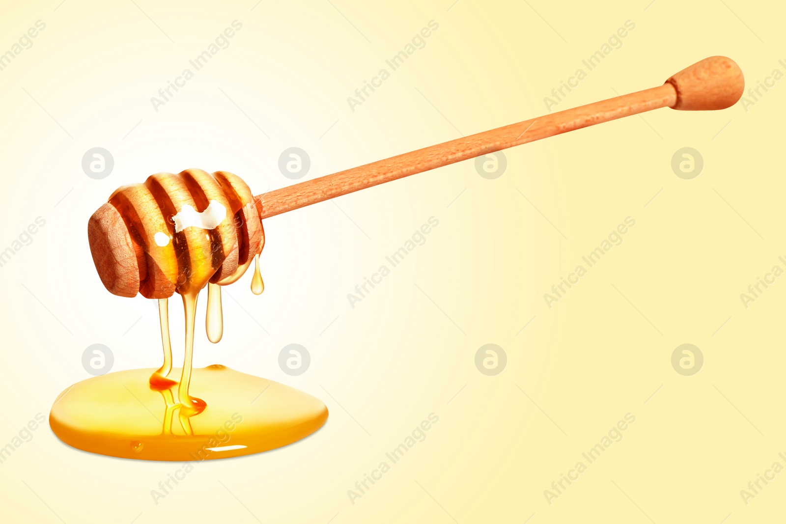 Image of Natural honey dripping from dipper on yellow background