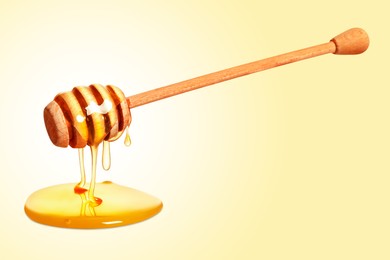 Natural honey dripping from dipper on yellow background