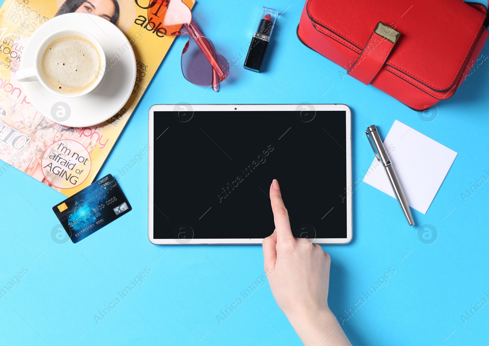 Photo of Online store. Woman using tablet on light blue background, top view