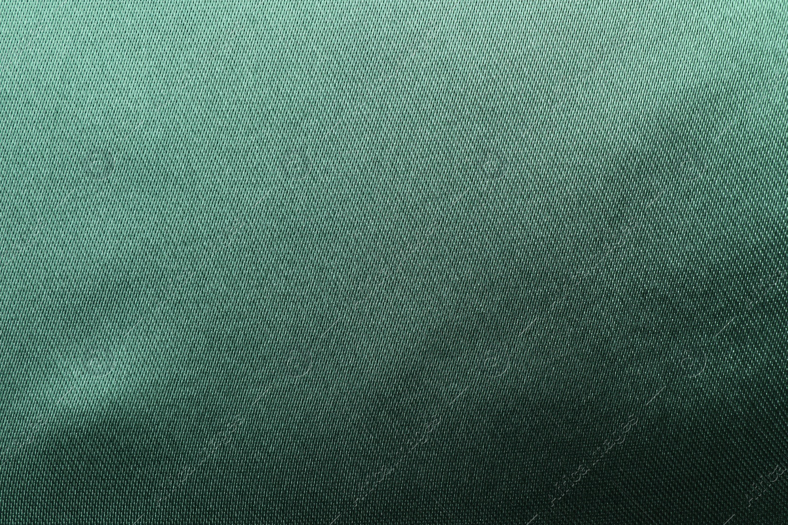 Photo of Texture of green silk fabric as background, top view