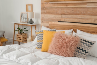 Photo of Stylish room interior with comfortable bed near wooden wall