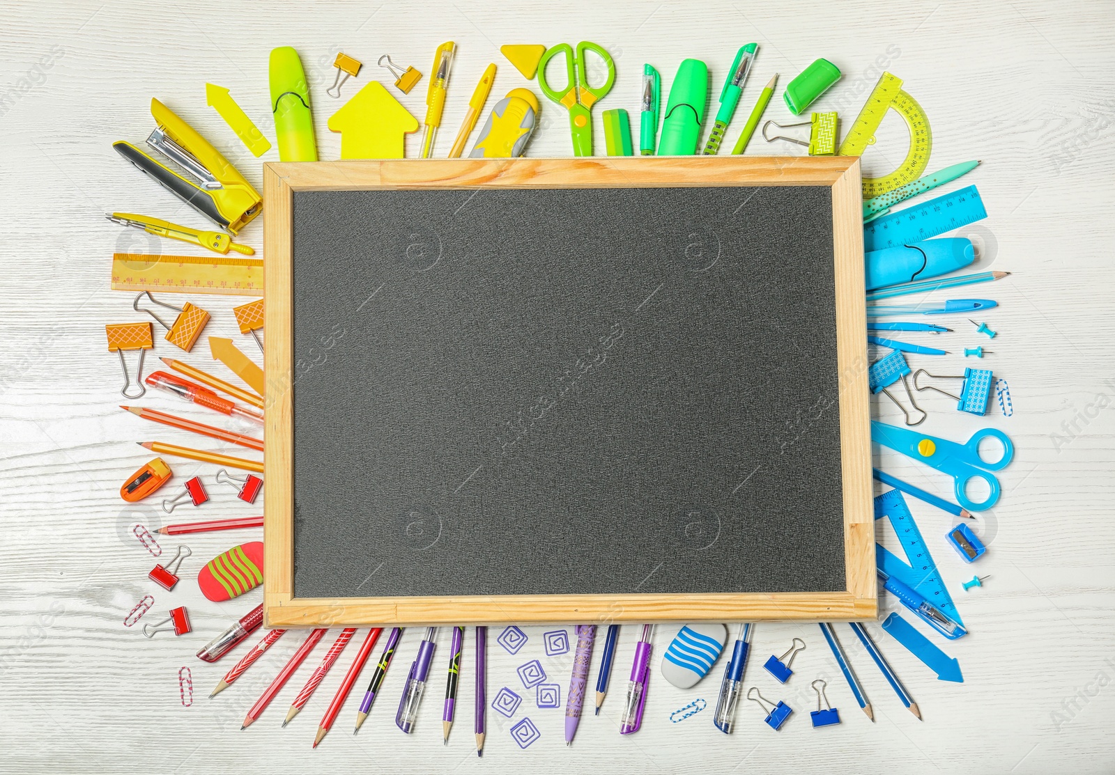 Photo of Flat lay composition with different school stationery and small chalkboard on wooden background