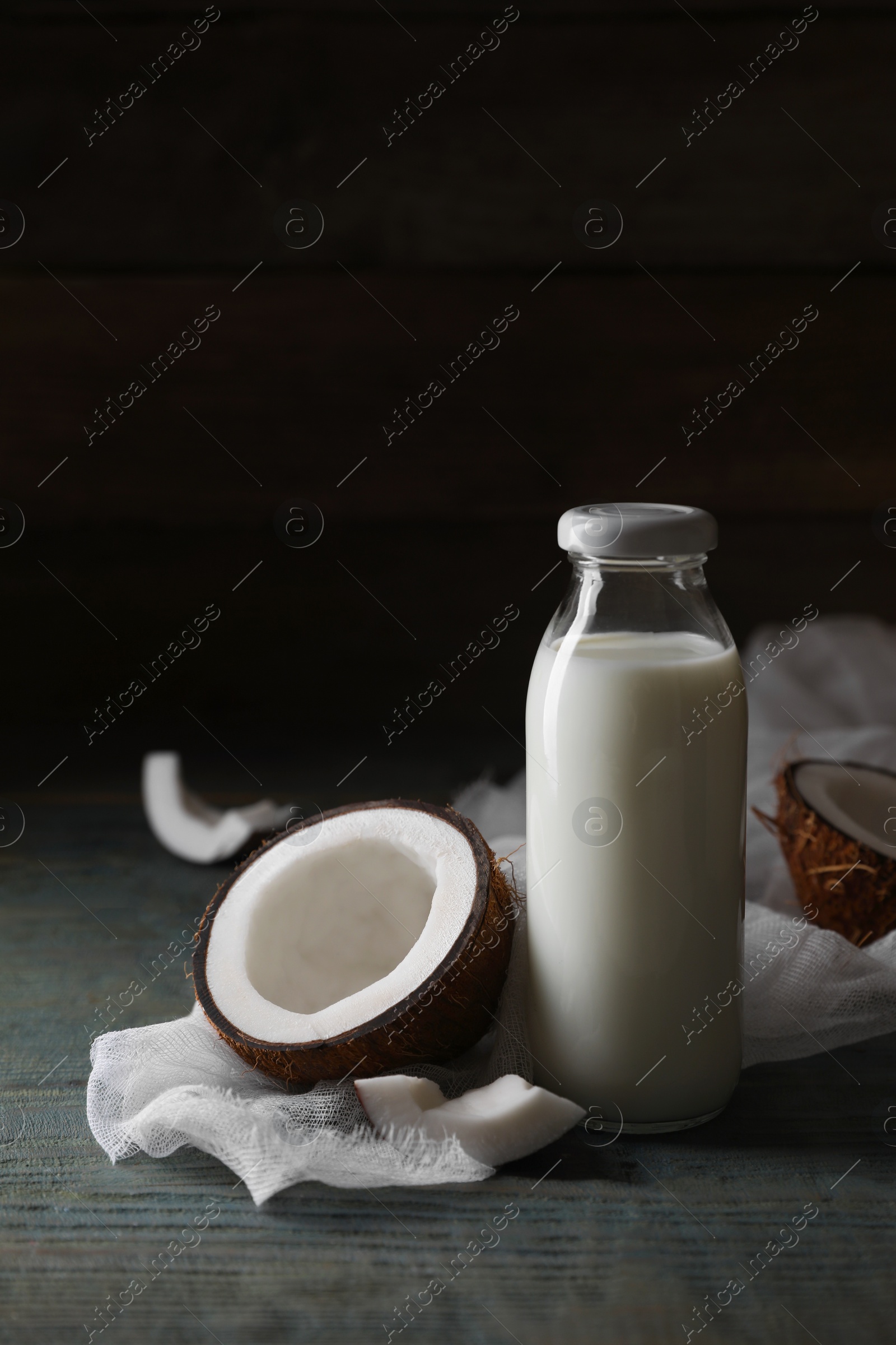 Photo of Bottle of coconut milk and nuts on wooden table