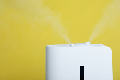 Modern air humidifier on yellow background, closeup