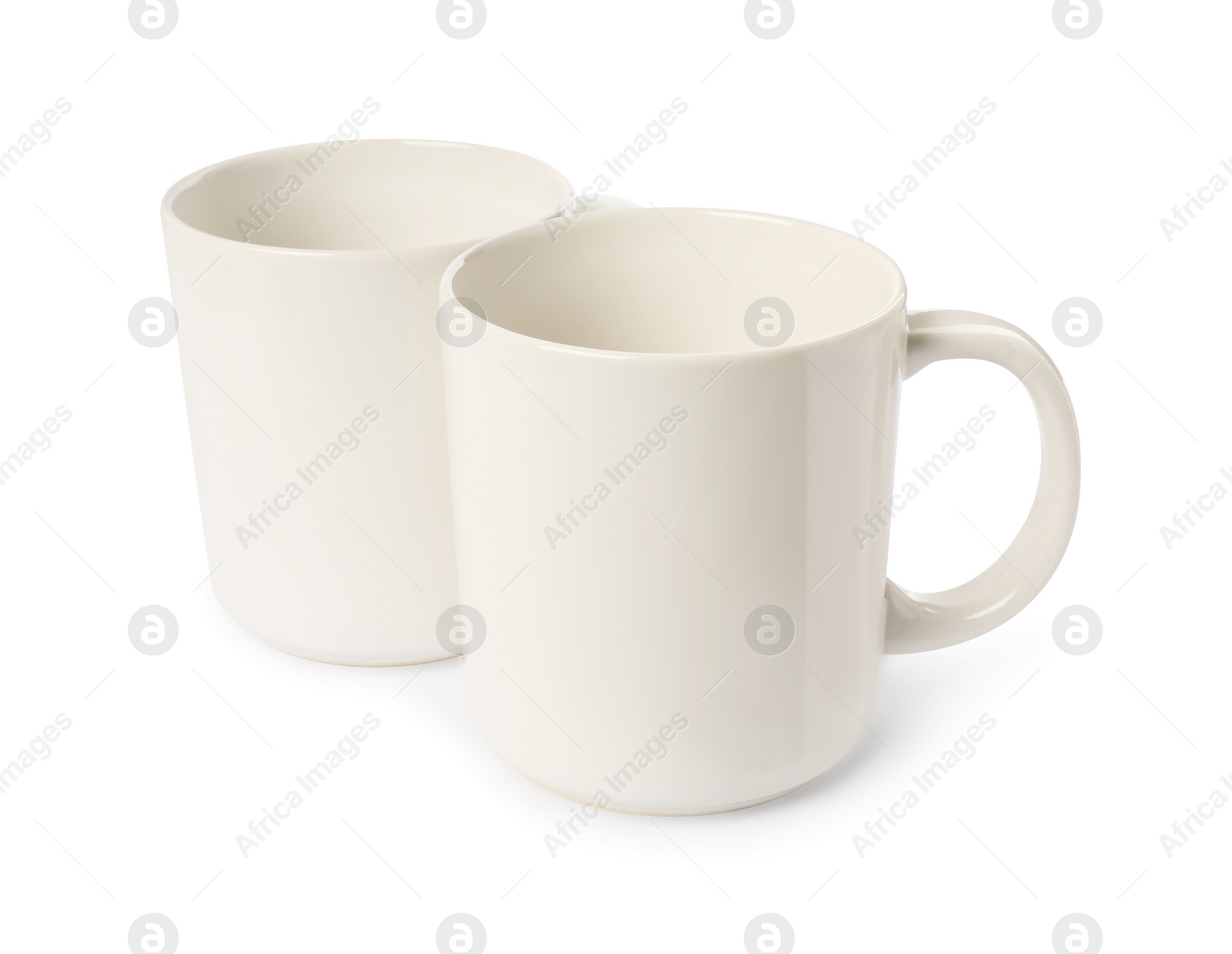 Photo of Two light ceramic mugs isolated on white