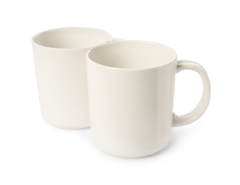 Photo of Two light ceramic mugs isolated on white