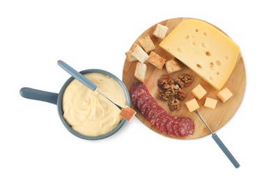 Fondue with tasty melted cheese, forks and different snacks isolated on white, top view