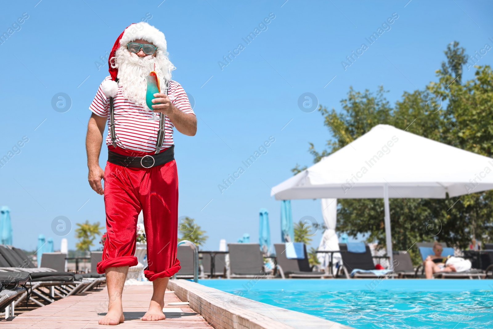 Photo of Authentic Santa Claus with cocktail near pool at resort