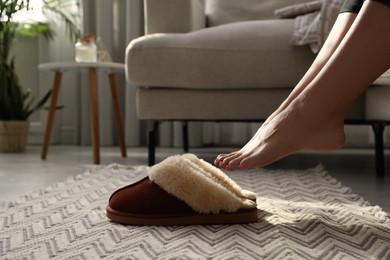 Photo of Woman with soft slippers at home, closeup