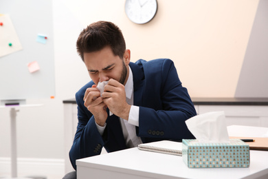 Photo of Sick young man at workplace. Influenza virus