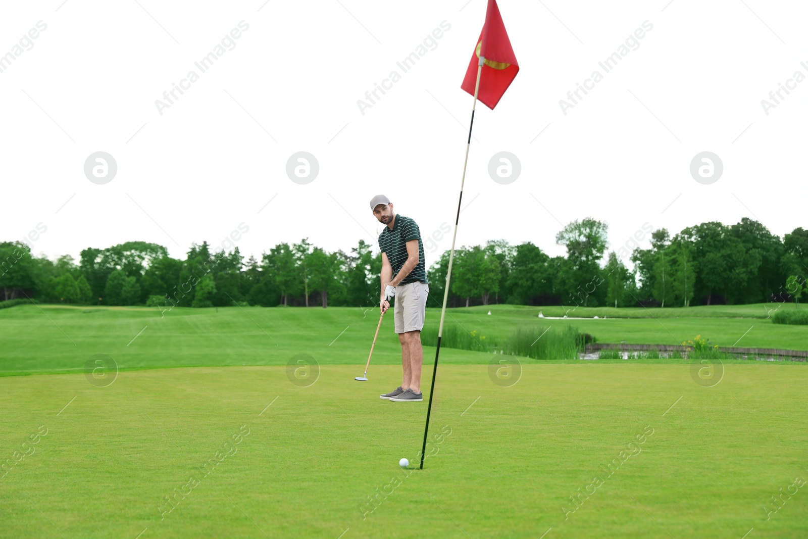 Photo of Man playing golf on green course. Sport and leisure