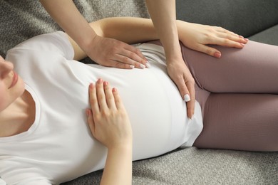 Photo of Doula taking care of pregnant woman at home, closeup. Preparation for child birth