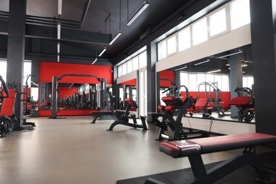 Spacious gym with professional equipment and mirrors
