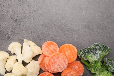 Photo of Different frozen vegetables on grey table, flat lay. Space for text