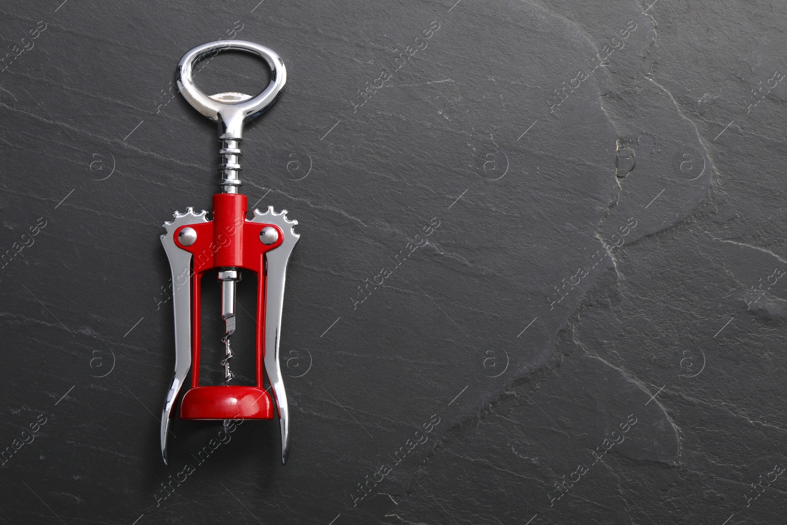 Photo of One wing corkscrew on grey textured table, top view. Space for text