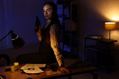 Professional detective with handgun in office at night. Space for text