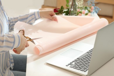 Photo of Woman making bouquet following online florist course at home, closeup. Time for hobby