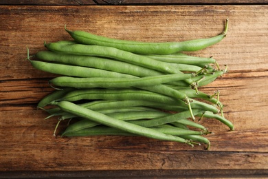 Photo of Fresh green beans on wooden table, flat lay