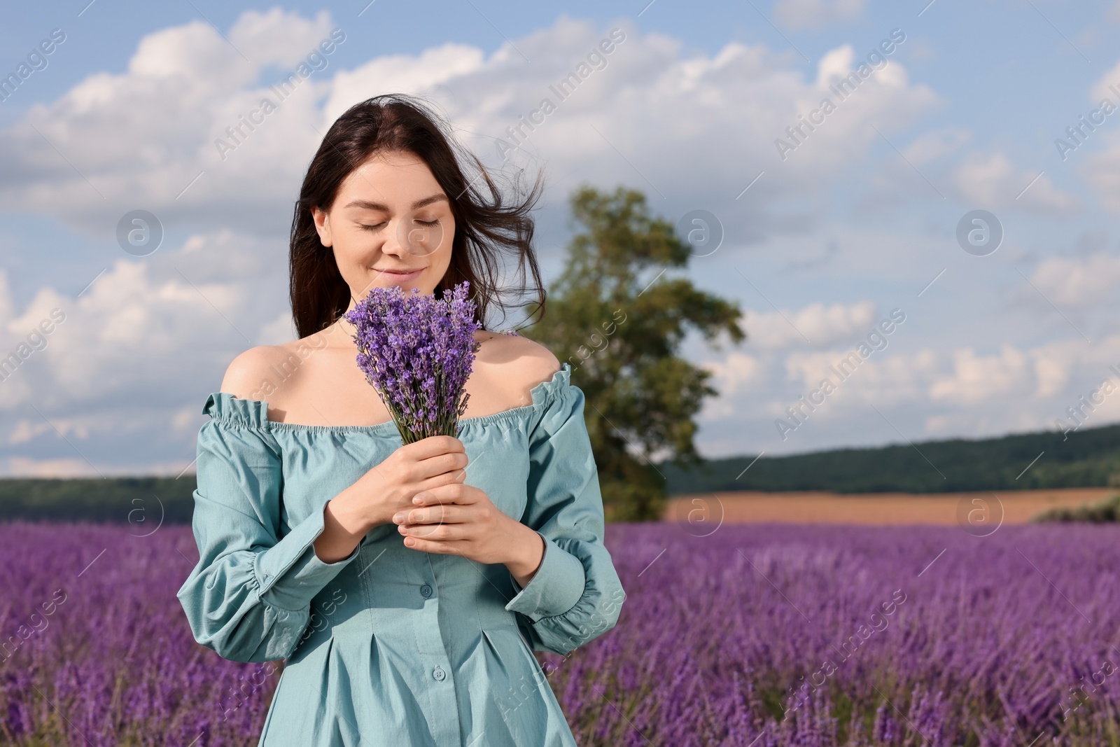 Photo of Beautiful woman with bouquet in lavender field. Space for text