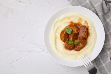 Photo of Delicious goulash served with mashed potato on white textured table, flat lay. Space for text